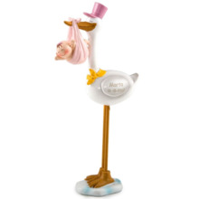 Figura de pastel de cigüeña con bebé y gorro rosa
