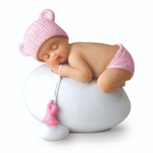 Figura niña bebé rosa durmiendo sobre huevo